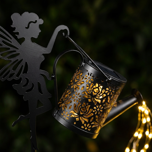 Close-up of the cut-metal fairy silhouette and floral watering can pattern, showing metal build quality